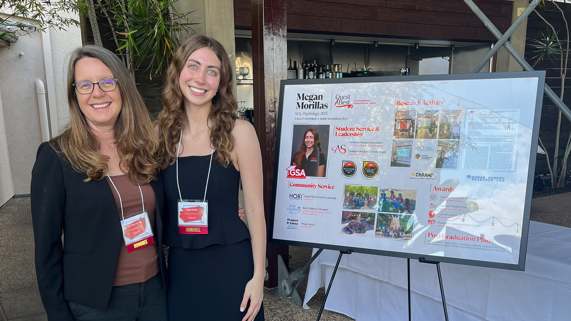 Robin Weersing and Megan Morillas standing outside near research poster