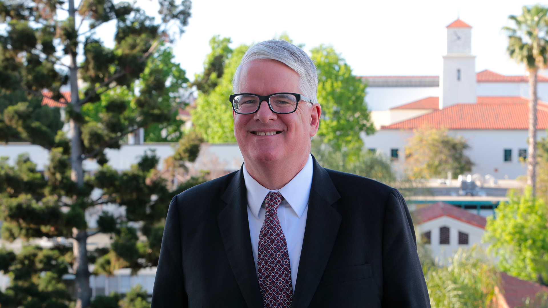 Wonderful portrait of Jeff Roberts standing on balcony overlooking SDSU campus.