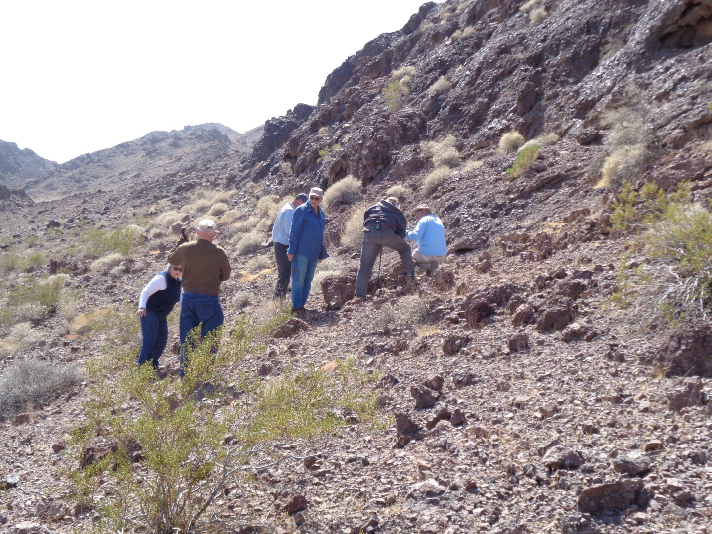 A small group of people look at geological features near Palo Verde, CA