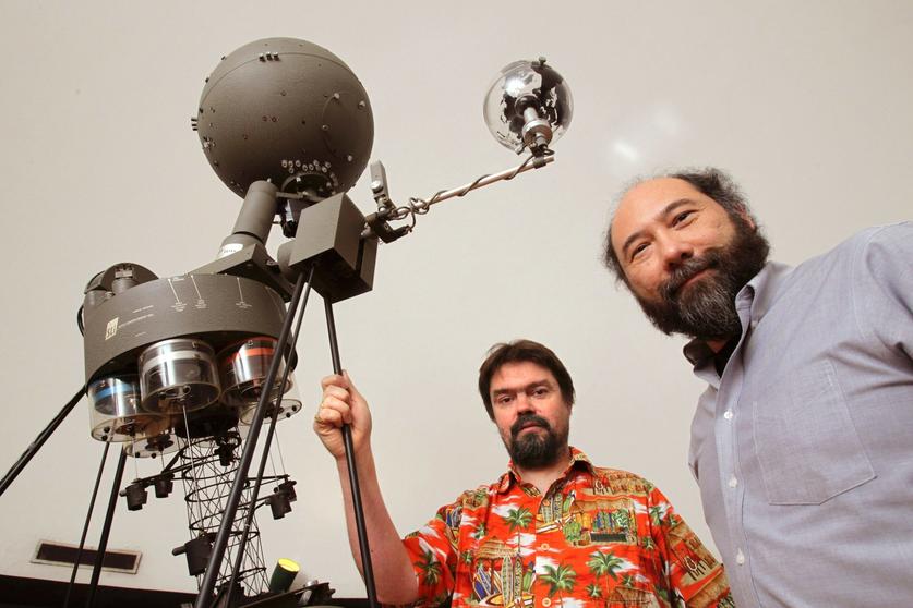 Jerome Orosz and Bill Welsh stand with spherical planetarium projector
