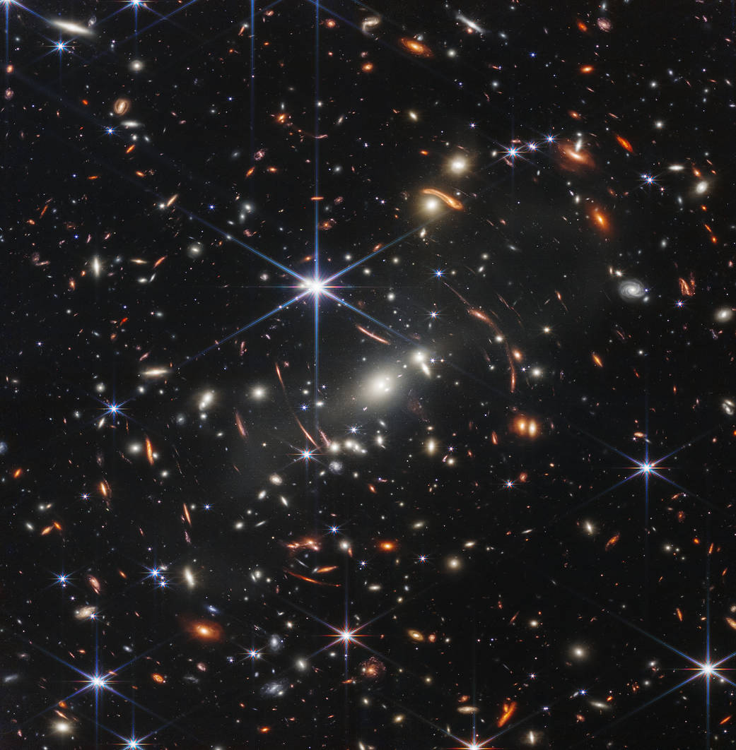 Thousands of white, orange and blue dots scattered across a black background from JWST's Deep Field