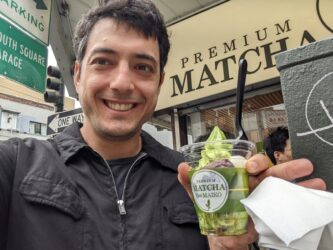 A selfie of a young man holding a cup of matcha ice cream