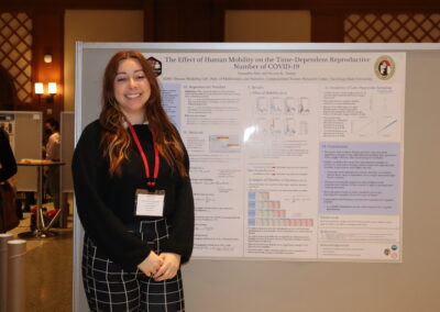 Student stands next to her poster about math and COVID-19 spread