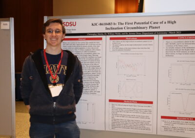Student stands next to his astronomy research