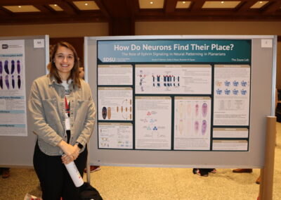 Student stands next to poster on ephrin in neurons