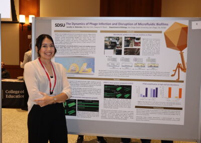Student stands by her poster on phage therapy