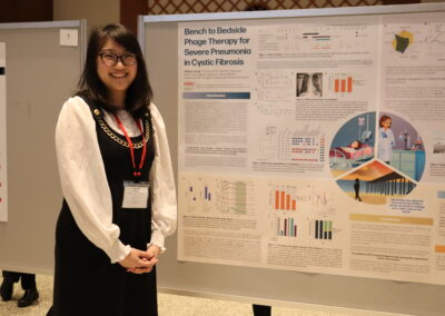 Student stands next to her poster on using phages to cure disease