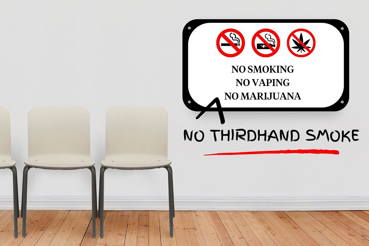 A room that contains three chairs and a sign that reads “NO SMOKING NO VAPING NO MARIJUANA” with a hand-drawn caret adding the words “NO THIRDHAND SMOKE,” underlined in red.