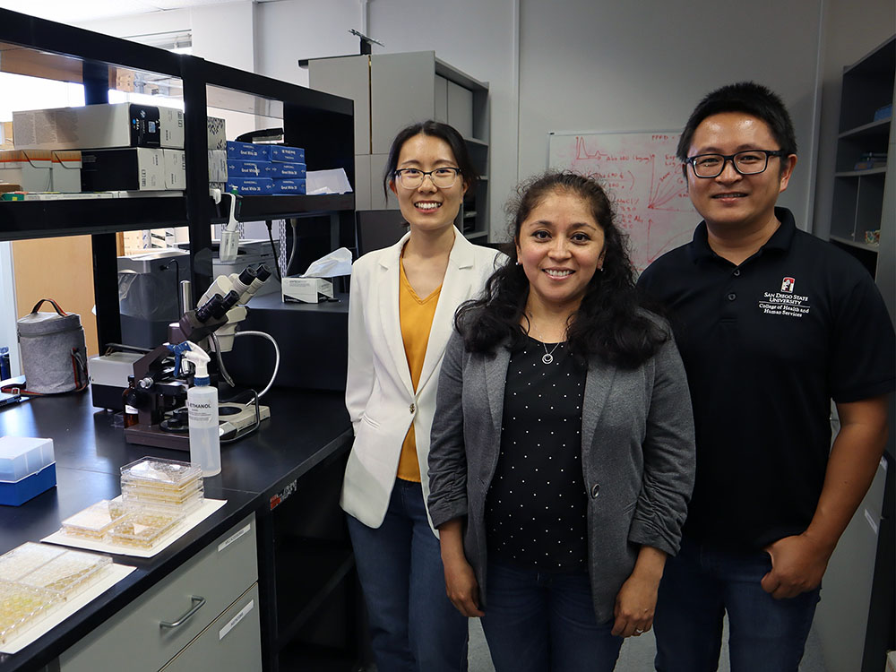 Jing Zhao, Cristal Zuniga, and Changqi Liu stand by their algae in a lab.