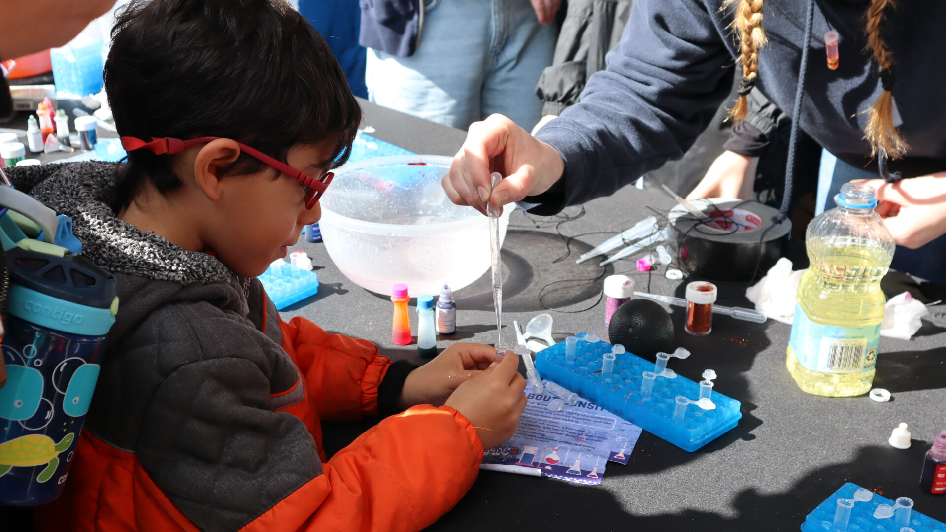 SDSU’s Society of Women Engineers facilitated a DIY mini lava lamp necklace activity to teach about liquid density