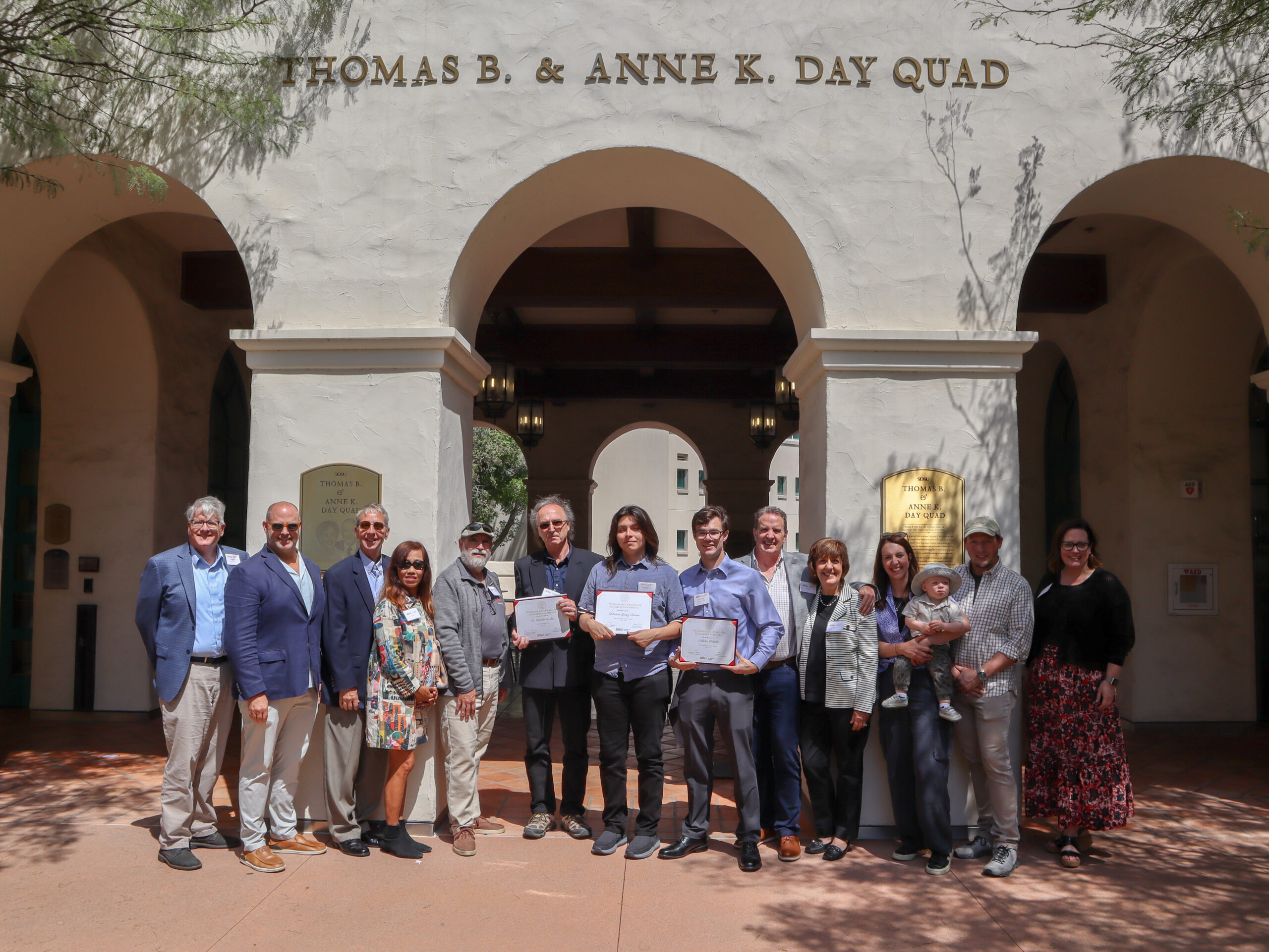 (From left to right) Dean Jeffrey Roberts, Adam Day, Brad Pitzer, Toy Pitzer, Sam Crivello, Professor Fridolin Weber, Sebastian Gomez-Barron, Nicholas Schottle, Tim Day, Krista Day, Meghan Day, Andrew Bollman and Vice Provost Sonjia Pruitt-Lord in Thomas B. & Anne K. Day Quad