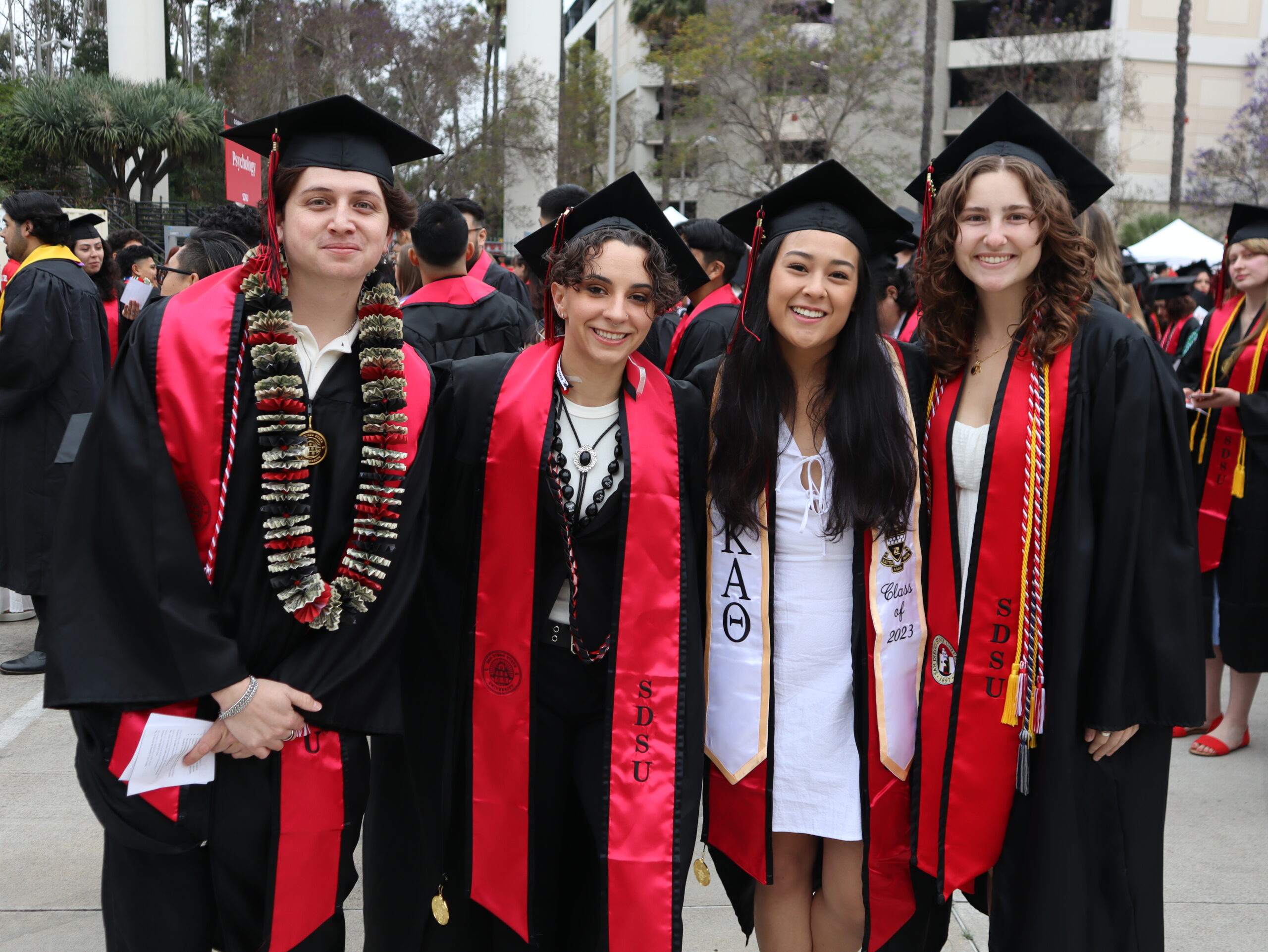 College of Sciences graduates pose for a photo in cap and gown