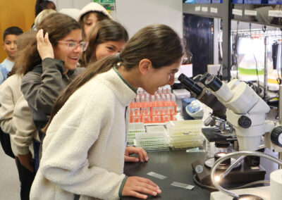 Students line up to examine algae samples up close in a microscope