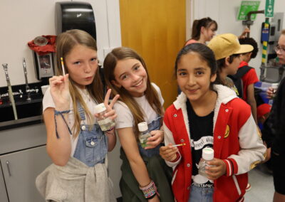 Local fifth grade students hold their algae samples and pH strips used to test them