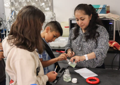 Cristal Zuniga assists local fifth grade students from Tracy Beach’s Northmont Elementary School class as they measure the biomass of algae samples