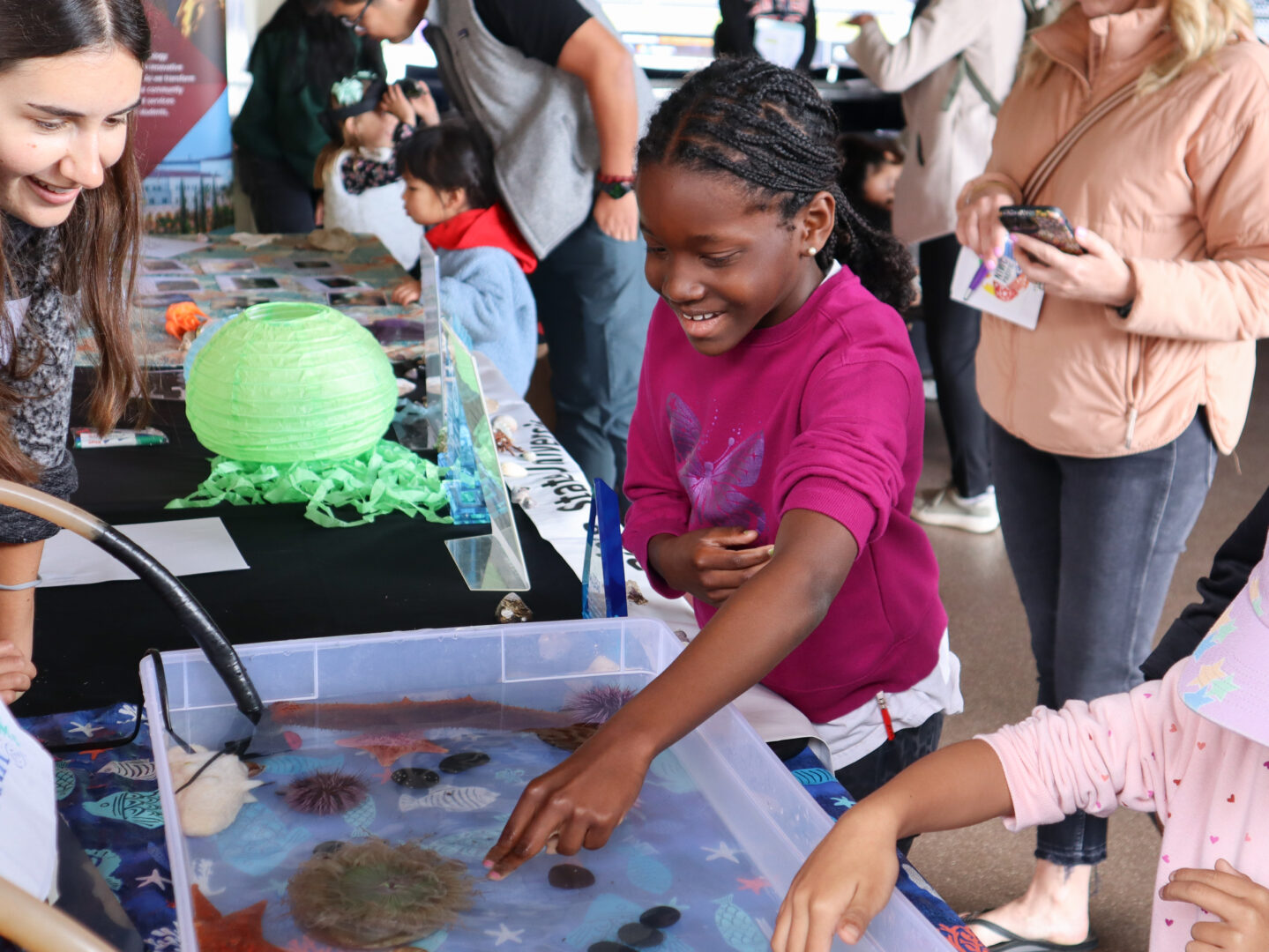 A young student smiles while exploring marine creatures at the 2025 San Diego Festival of Science and Engineering