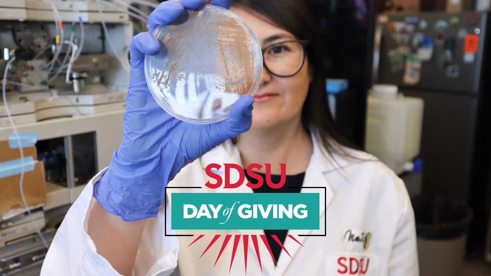 Graphic of a scientist with text that reads: SDSU DAY OF GIVING